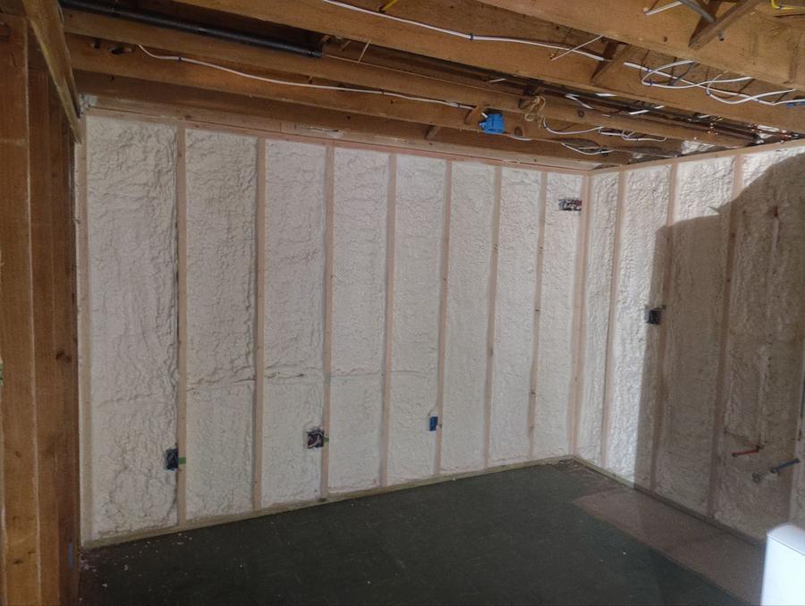 Spray foam filling the framed basement wall cavities, Meriden, CT