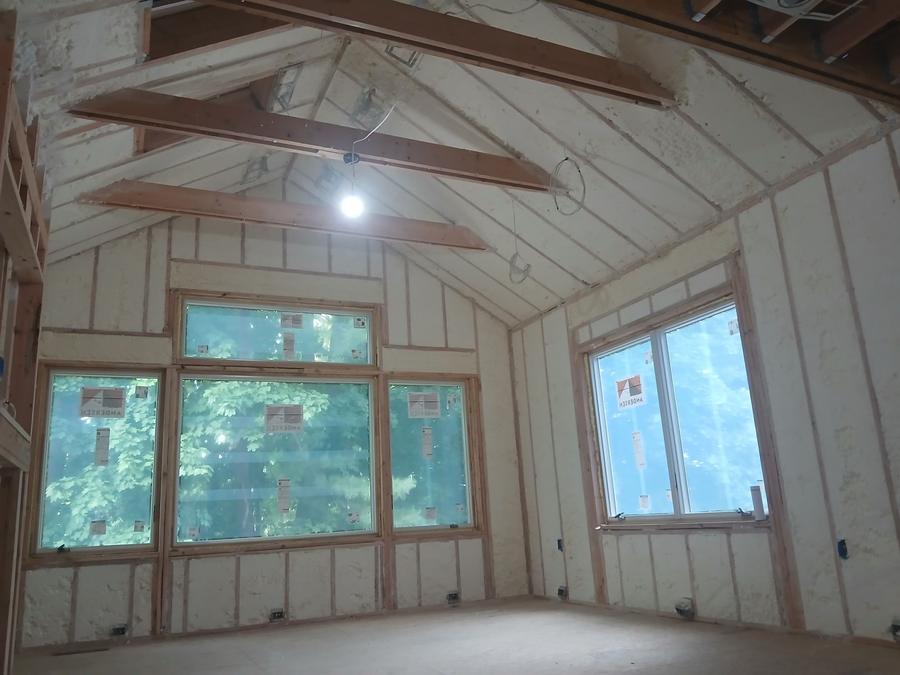 Spray foam on the walls and vaulted ceiling of a bright room, Ardsley, NY