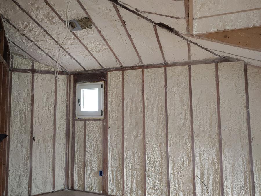Spray foam filling the wall and sloped ceiling bays around a small window, Dobbs Ferry, NY