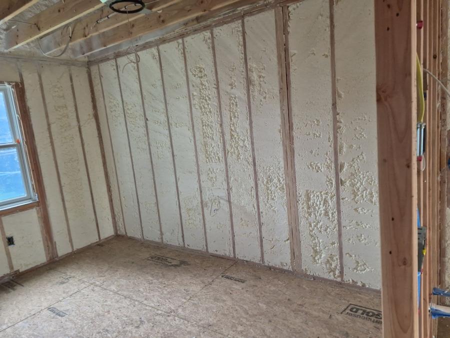 Spray foam filling the stud bays of an exterior wall, Harrison, NY