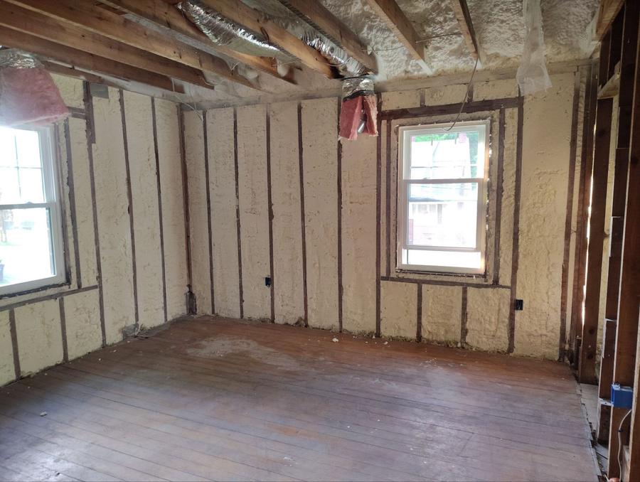 Spray foam filling the exterior wall bays of a room with wood floors, Poughkeepsie, NY