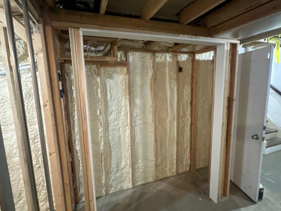 Spray foam lining the walls of a framed basement closet, Briarcliff Manor, NY