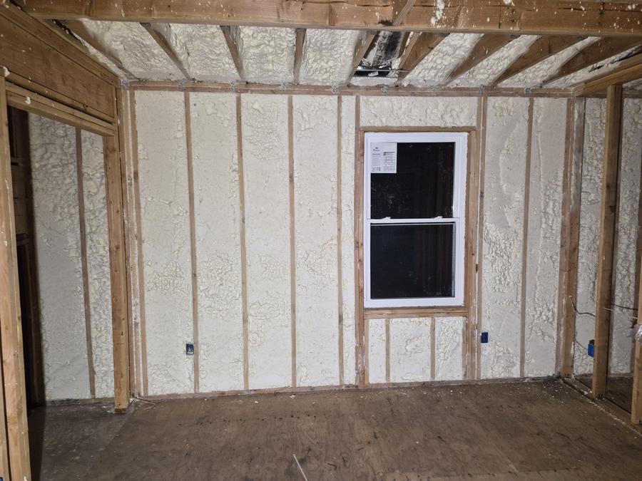 Spray foam filling the wall cavities around a new window, Passaic, NJ