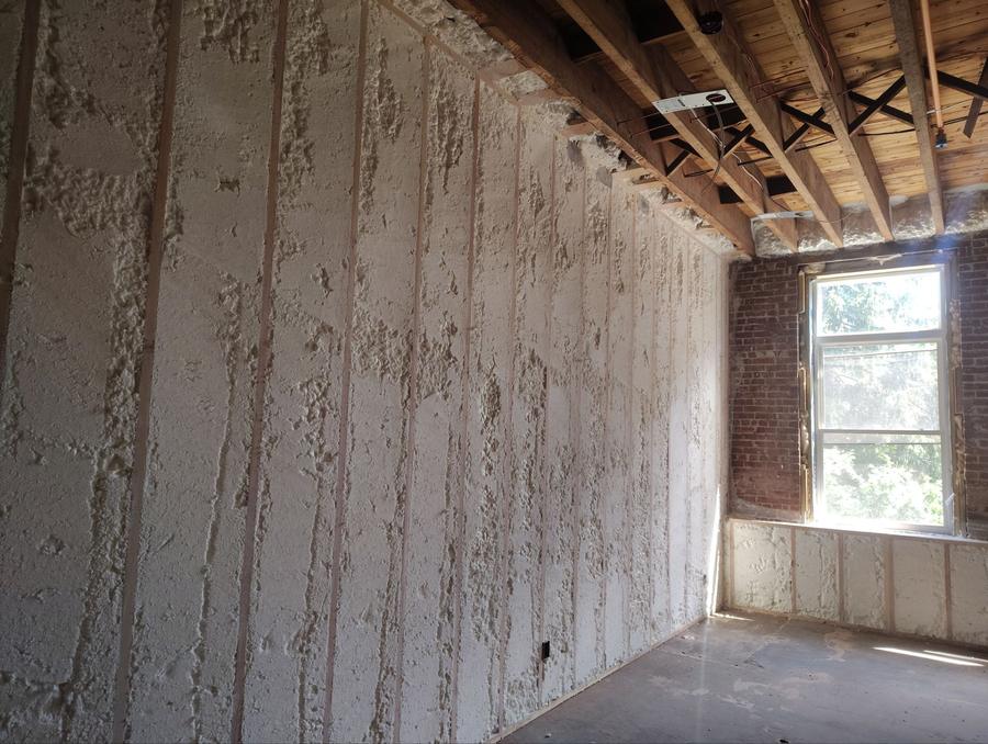 Spray foam covering a framed wall inside a brick building, Plymouth, CT