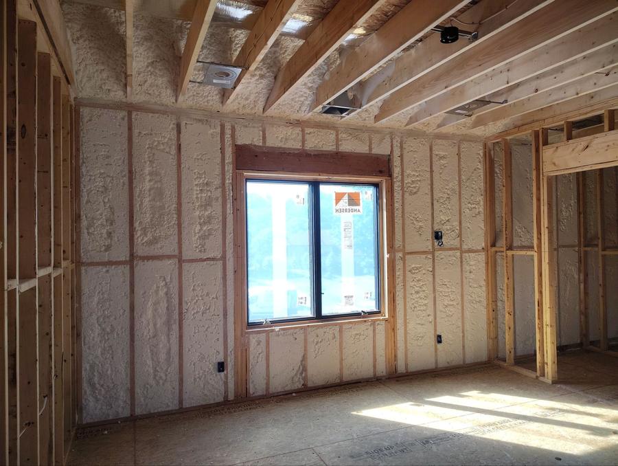 Spray foam filling exterior wall cavities around a window, Newburgh, NY