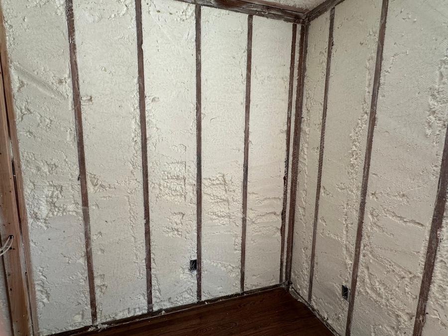 Spray foam filling the wall cavities in a room corner, Brightwaters, NY