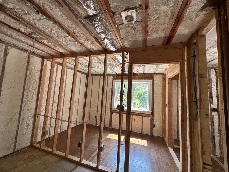 Spray foam covering the ceiling and outer walls of a gutted room, Rye, NY