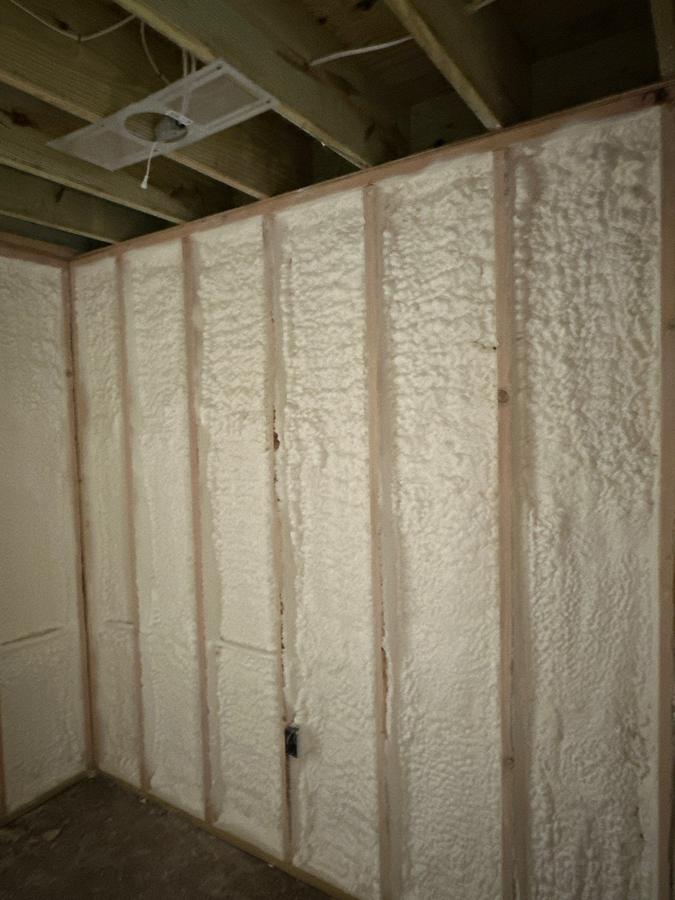 Spray foam filling the stud bays of a basement wall, Mahwah, NJ